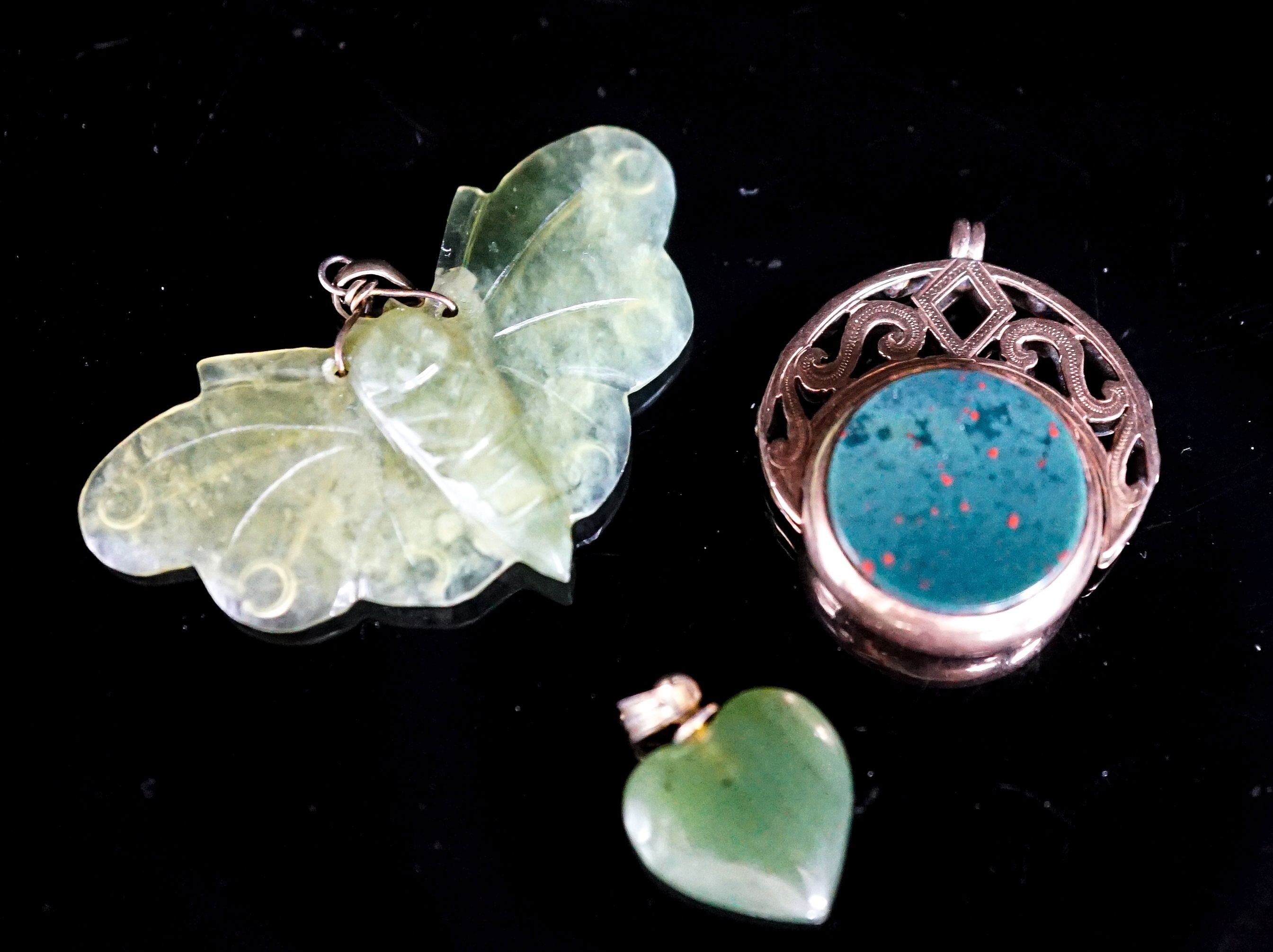 A nephrite moth pendant, 46mm, a similar heart pendant and a yellow metal mounted chalcedony spinning fob seal.